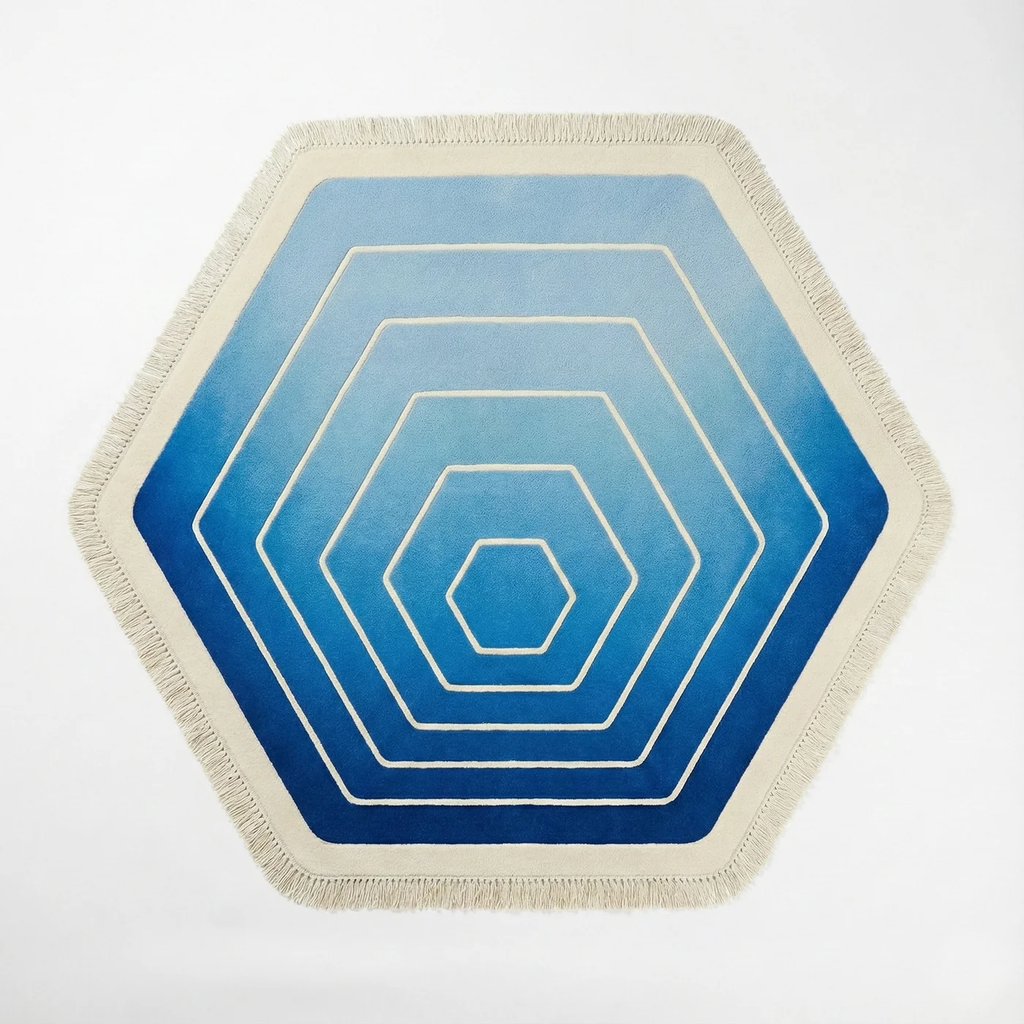Hexagonal area rug with a concentric hexagon pattern in shades of blue and white, finished with a cream fringed border, shown on a plain white background.